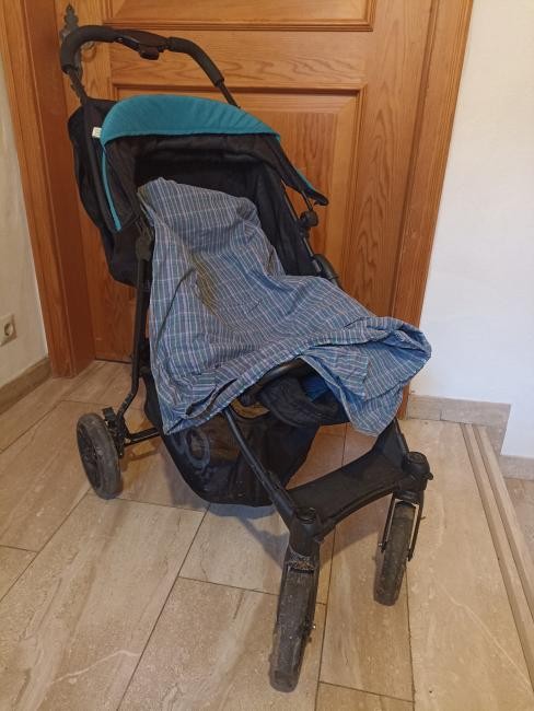 Foto eines schwarzen Kinderwagens mit blau-karrierter Decke